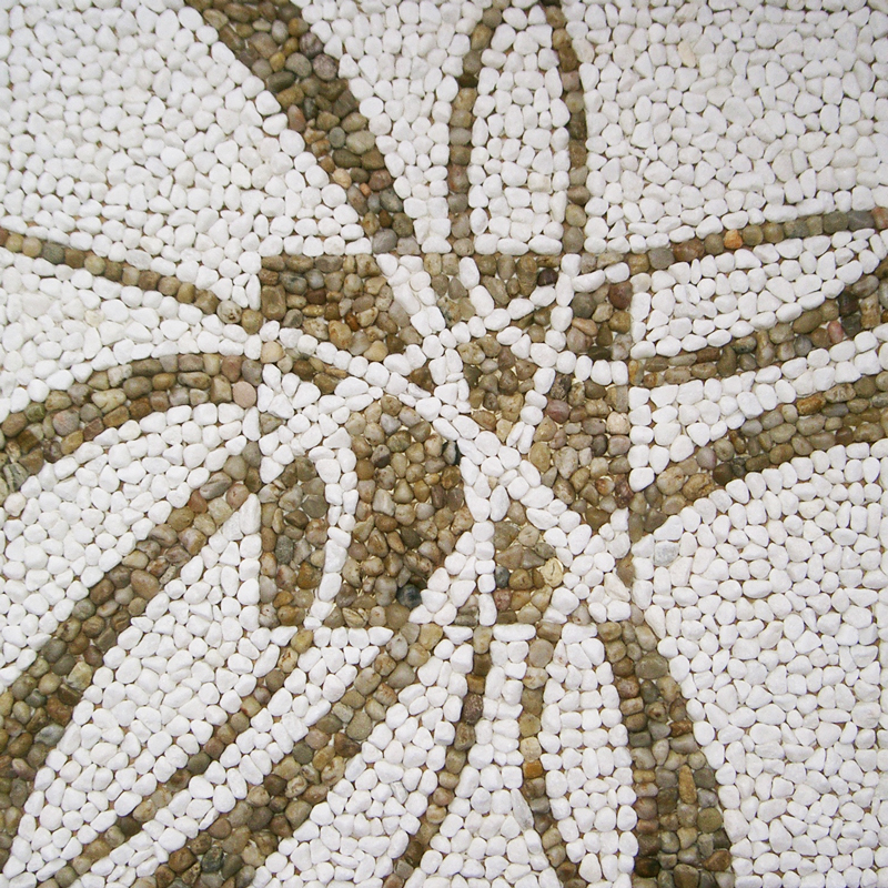 Mosaik aus Kieselsteinen; geschwungene in der Stärke sich verändernde Linien kreuzen in der Bildmitte in einem negativ farbigem Quadrat
